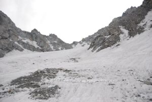 Crossing the final snow ridge.